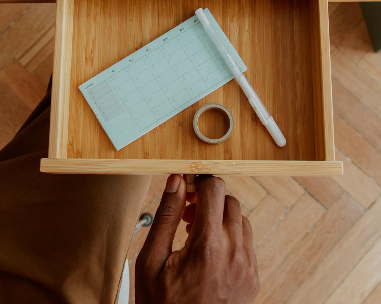 a person organizing a small drawer